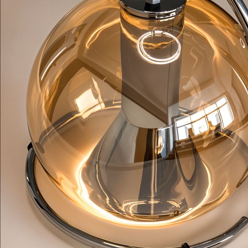 Close-up of the Clérachic pendant light's champagne glass dome and chrome ring, showing the warm bulb glowing inside.