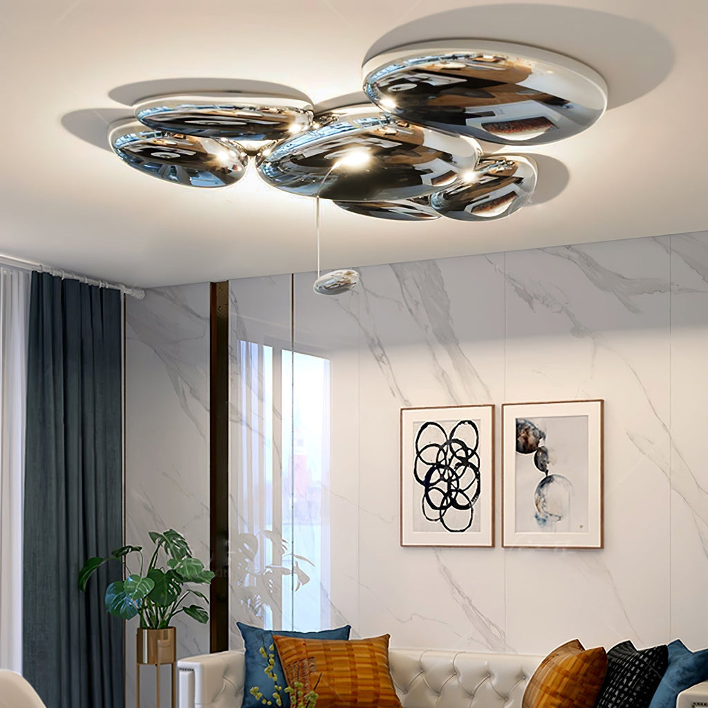 Clérachic 6-head Chrome Ceiling Light above a tufted sofa, veined marble wall, and a plant in a gold planter.