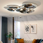 Clérachic 6-head Chrome Ceiling Light above a tufted sofa, veined marble wall, and a plant in a gold planter.