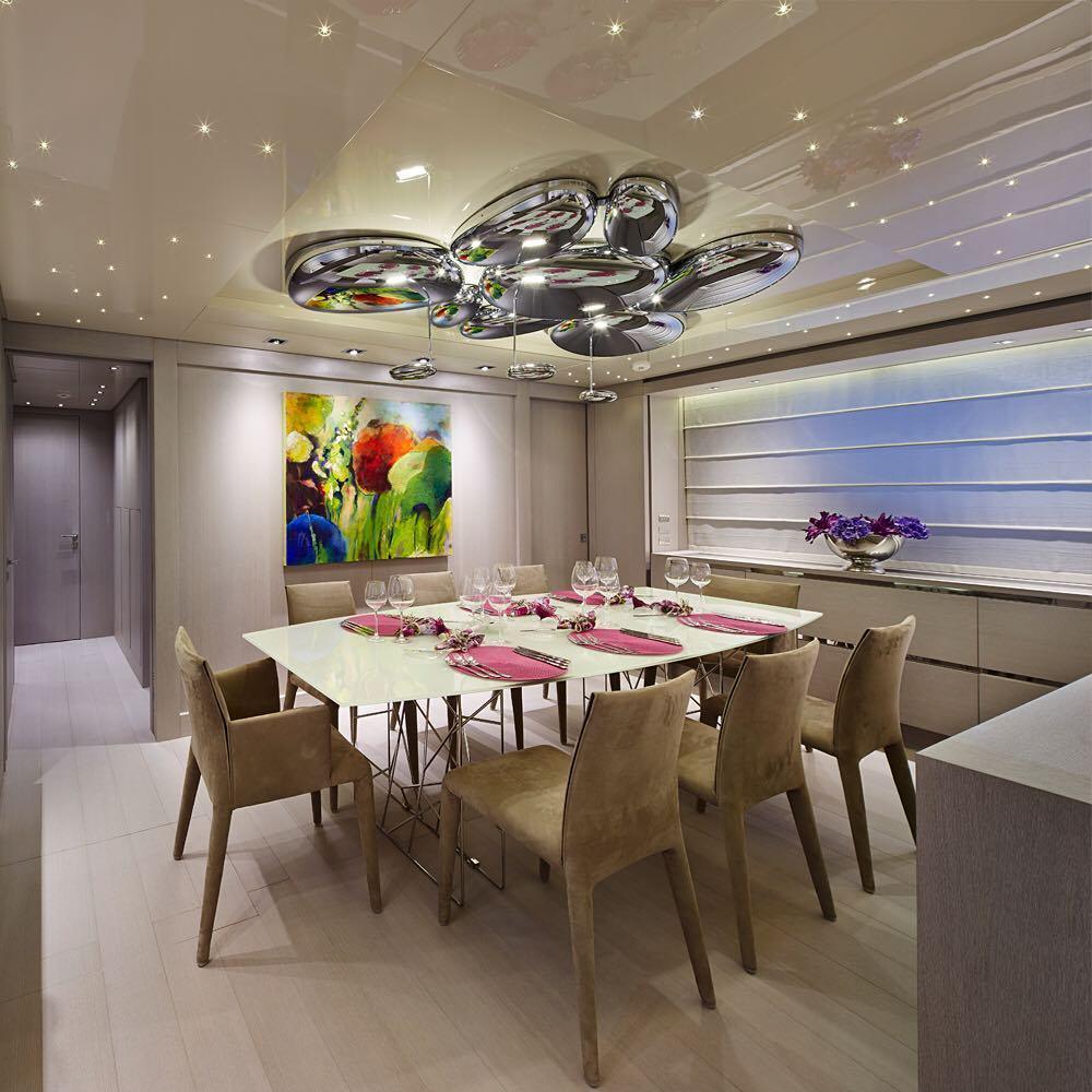 Clérachic 6-head Chrome Ceiling Light over a set dining table, chrome pebbles reflecting a colorful painting.