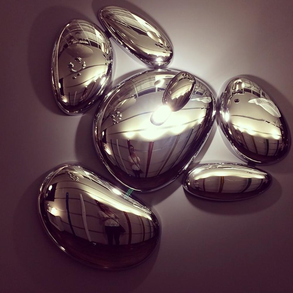 Close-up of the Clérachic 6-head Chrome Ceiling Light, one pebble glowing while the others mirror the room.