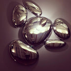 Close-up of the Clérachic 6-head Chrome Ceiling Light, one pebble glowing while the others mirror the room.