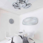 Clérachic 6-head Chrome Ceiling Light above a round white table and four white cantilevered chairs.