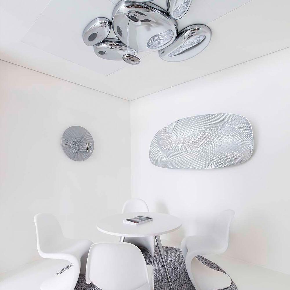 Clérachic 6-head Chrome Ceiling Light above a round white table and four white cantilevered chairs.