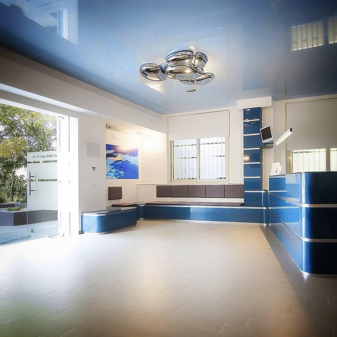 Clérachic 6-head Chrome Ceiling Light on a glossy blue ceiling above a curved reception desk and blue benches.