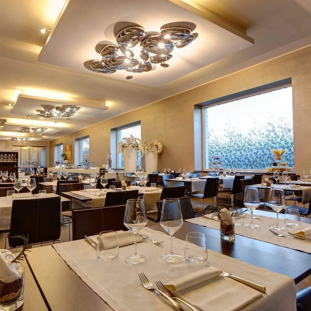 Clérachic 6-head Chrome Ceiling Lights in a row above restaurant tables set with white linen and wine glasses.