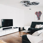 Clérachic 6-head Chrome Ceiling Light in a living room with a dark sofa and a colorful elephant painting.