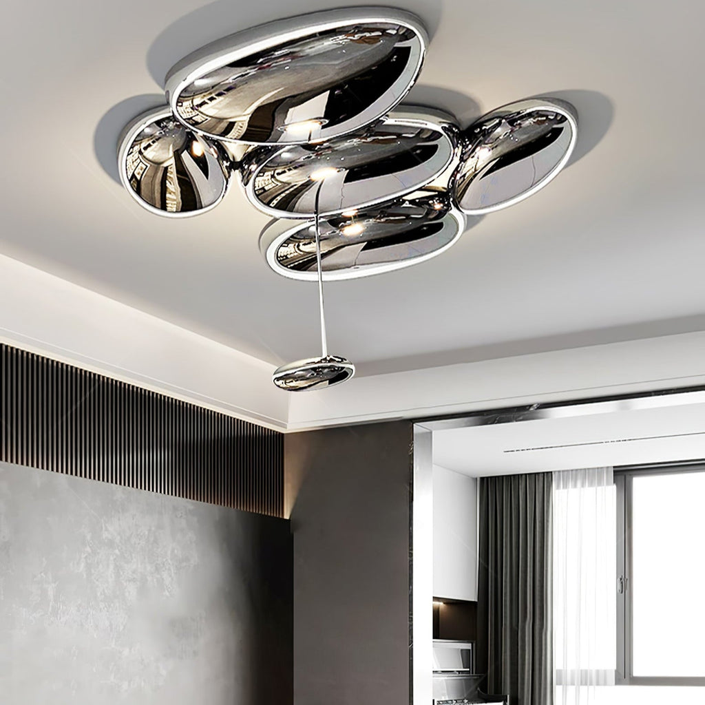 Clérachic 6-head Chrome Ceiling Light, five flush pebbles and one drop beside a grey slatted wall and drapes.