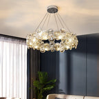 Lit round Clérachic crystal chandelier in a bedroom with a navy wall, sheer curtains and a potted palm.