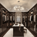 A Clérachic round crystal chandelier hangs in a dressing room with glass-fronted wardrobes and a marble-topped island.