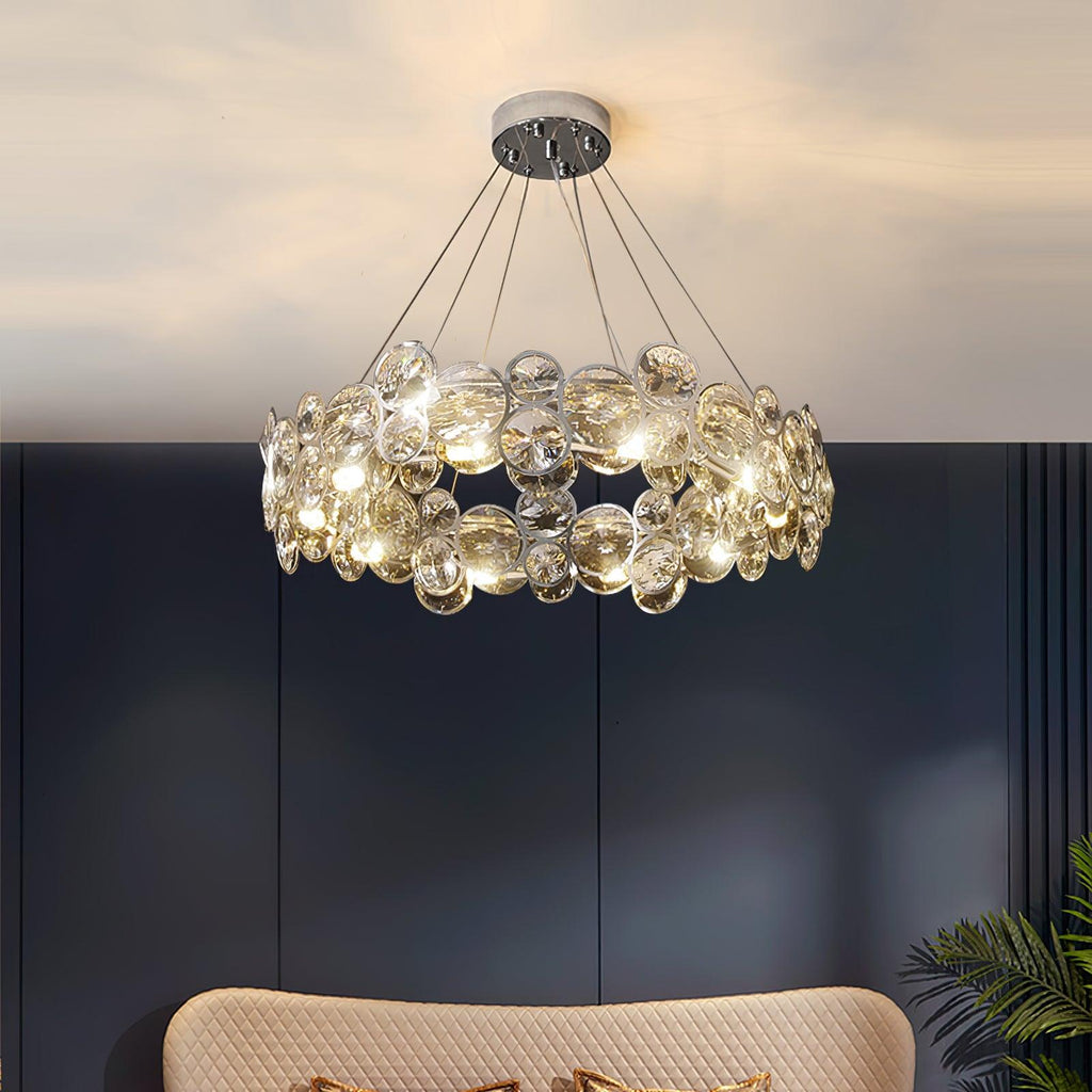 Low view of this Clérachic crystal chandelier lit against a navy wall, with a cream sofa back below.