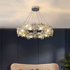 Low view of this Clérachic crystal chandelier lit against a navy wall, with a cream sofa back below.