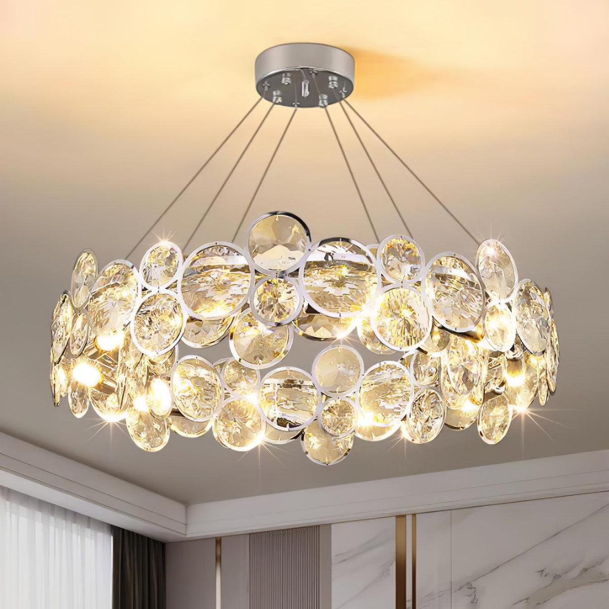 Close view of the chrome-rimmed crystal discs and the five suspension cables on this Clérachic chandelier.