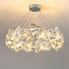 Front view of the lit round Clérachic chandelier, with its two bands of chrome-rimmed crystal discs.