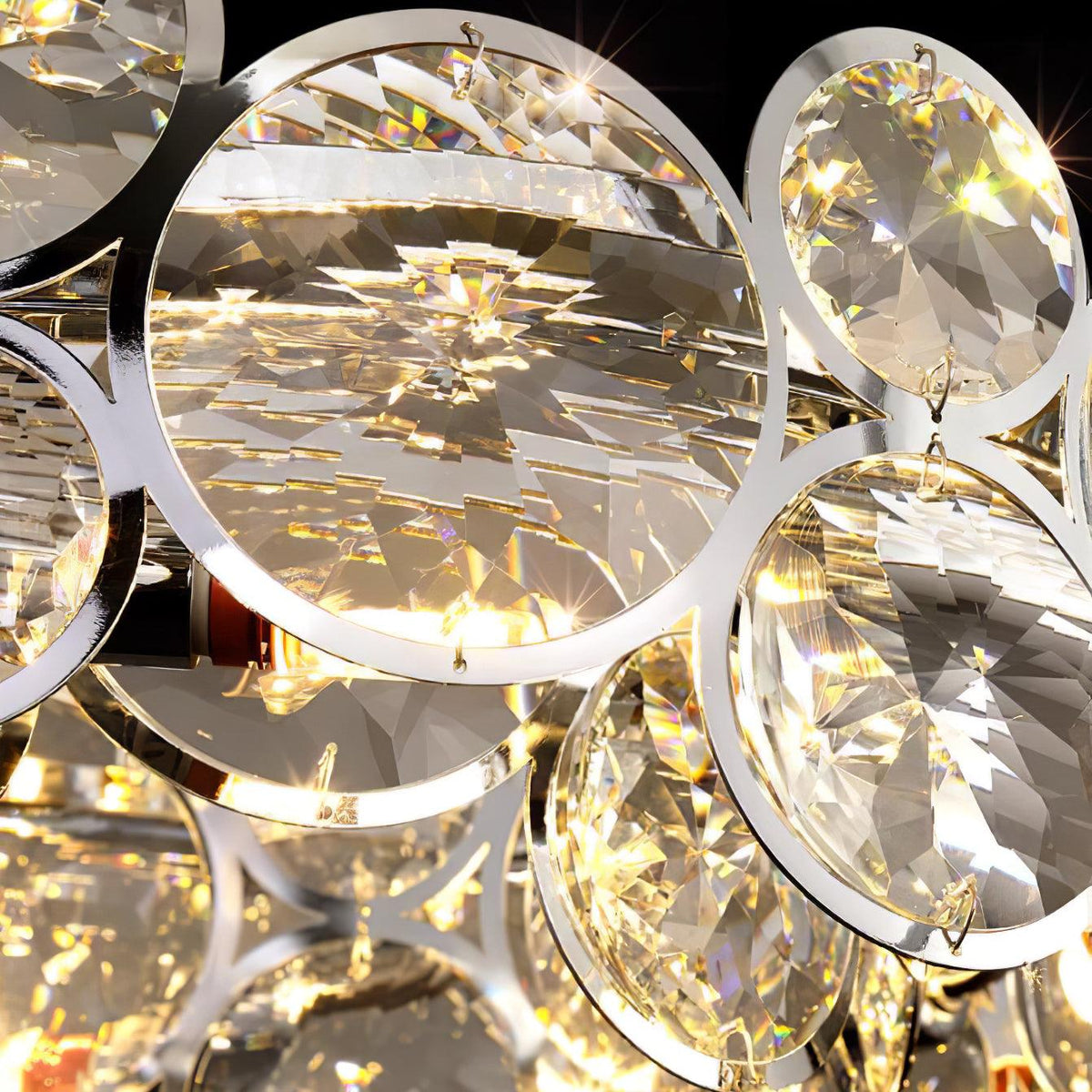 Close view of a large faceted crystal disc held in a polished chrome ring on this Clérachic chandelier.
