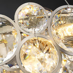 Close view of faceted crystal discs and their chrome rings, with warm light inside this Clérachic chandelier.