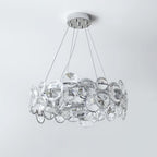 Unlit Clérachic crystal chandelier on a pale grey backdrop, showing the clear discs set in chrome rings.