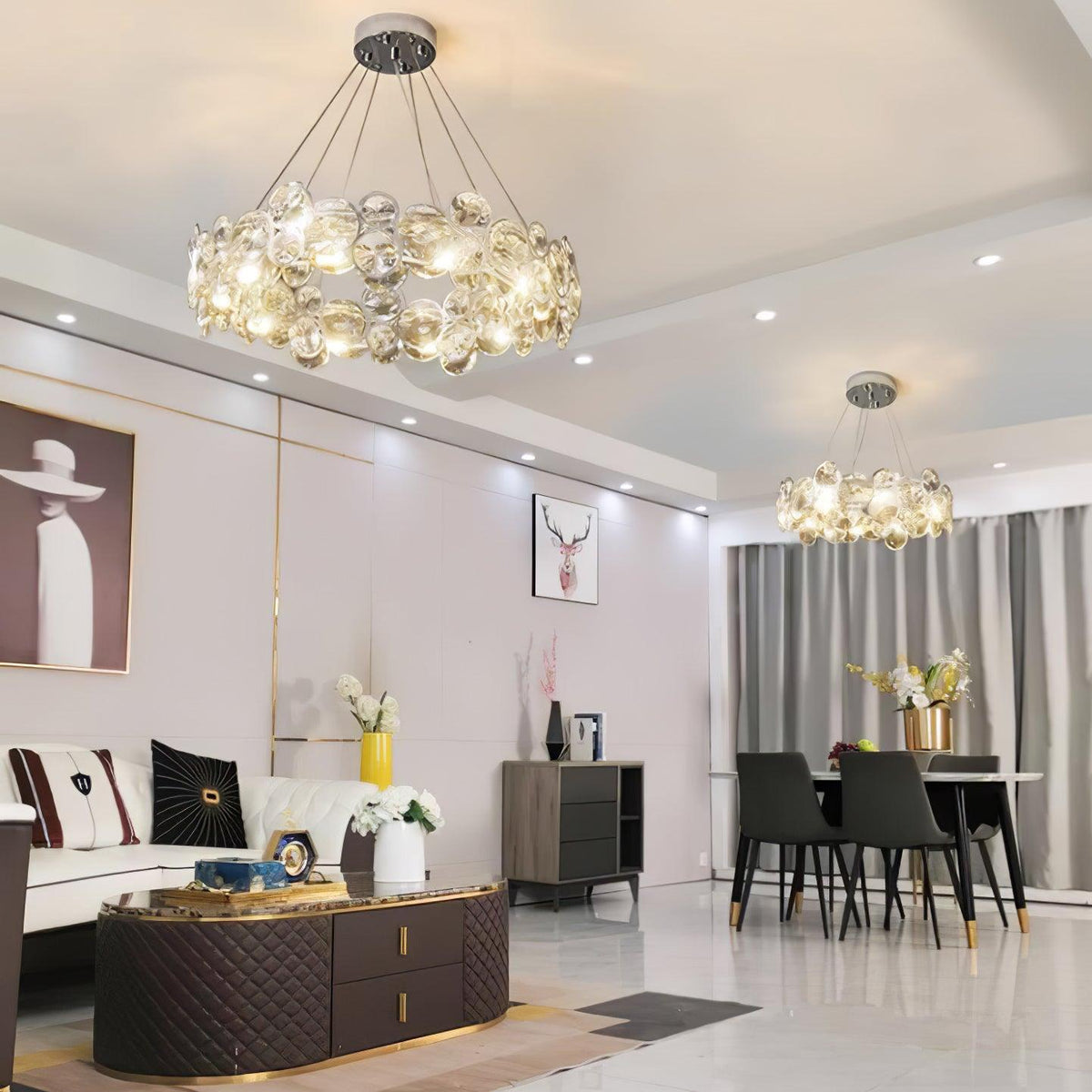 Two Clérachic crystal chandeliers light an open-plan living and dining room with a quilted coffee table.