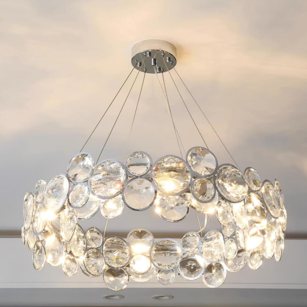 Slightly lower view of the lit Clérachic crystal chandelier, with the glowing bulbs between the clear discs.