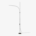 A Clérachic slender chrome floor lamp with a curved arm and square base, shown on a plain white backdrop with its cord trailing.