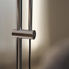 Close view of the chrome sliding collar and black cord on the twin poles of this Clérachic floor lamp.