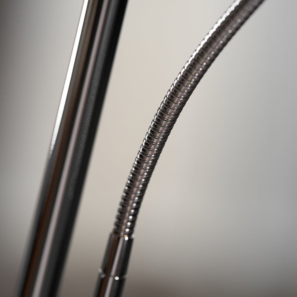 Close view of the flexible, ribbed chrome neck where the arm of this Clérachic floor lamp meets the pole.