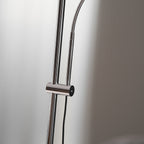 Close view of the chrome poles, sliding collar and flexible neck on this Clérachic floor lamp, with its black cord.