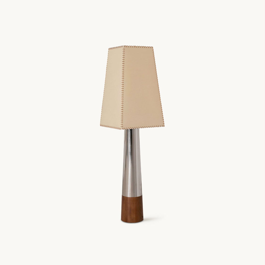 A Clérachic floor lamp on a plain white backdrop, with a tapered beige shade, a slim chrome stem and a dark walnut-coloured base.