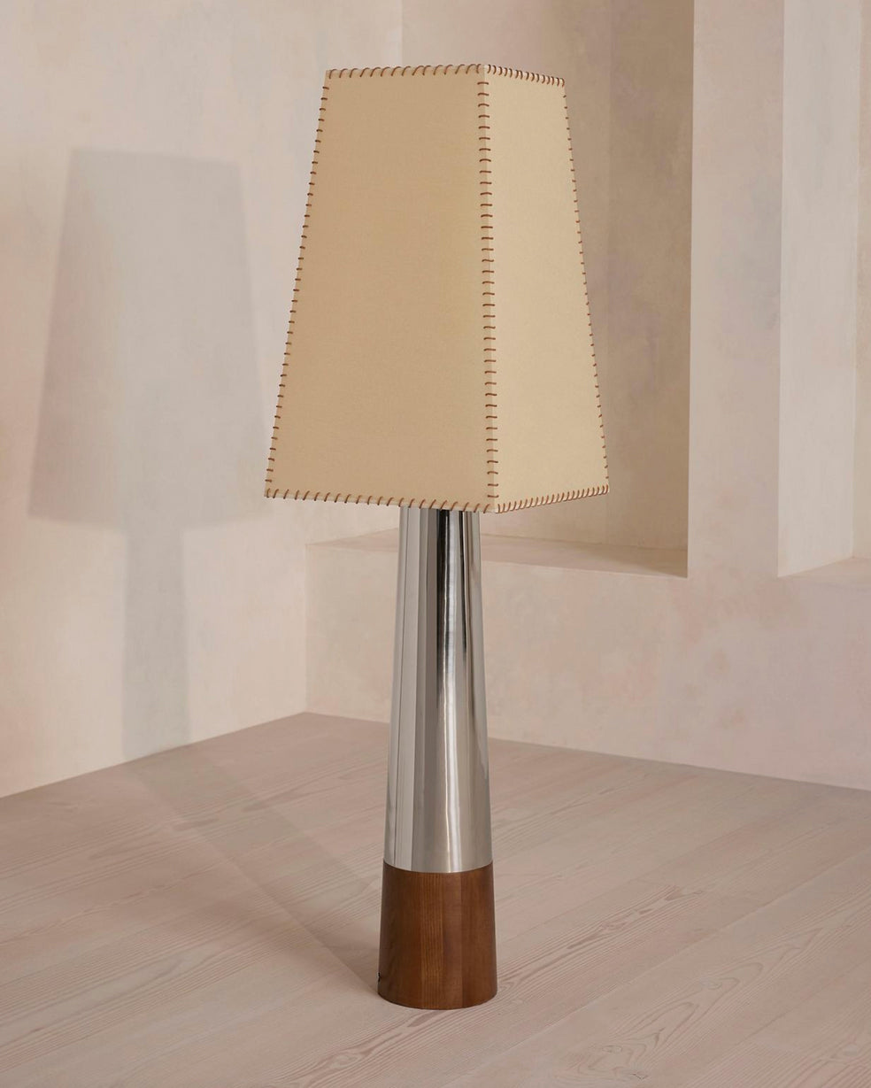 This Clérachic floor lamp unlit in a pale plaster corner, the tapered beige shade stitched at its edges above a chrome stem.