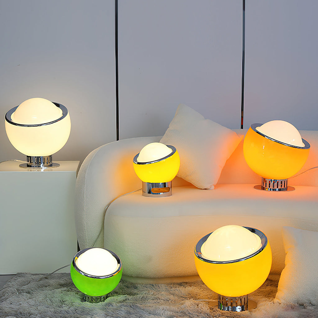 Several Clérachic table lamps in white, orange, green and a brighter yellow glowing around a cream sofa in a softly lit living room.