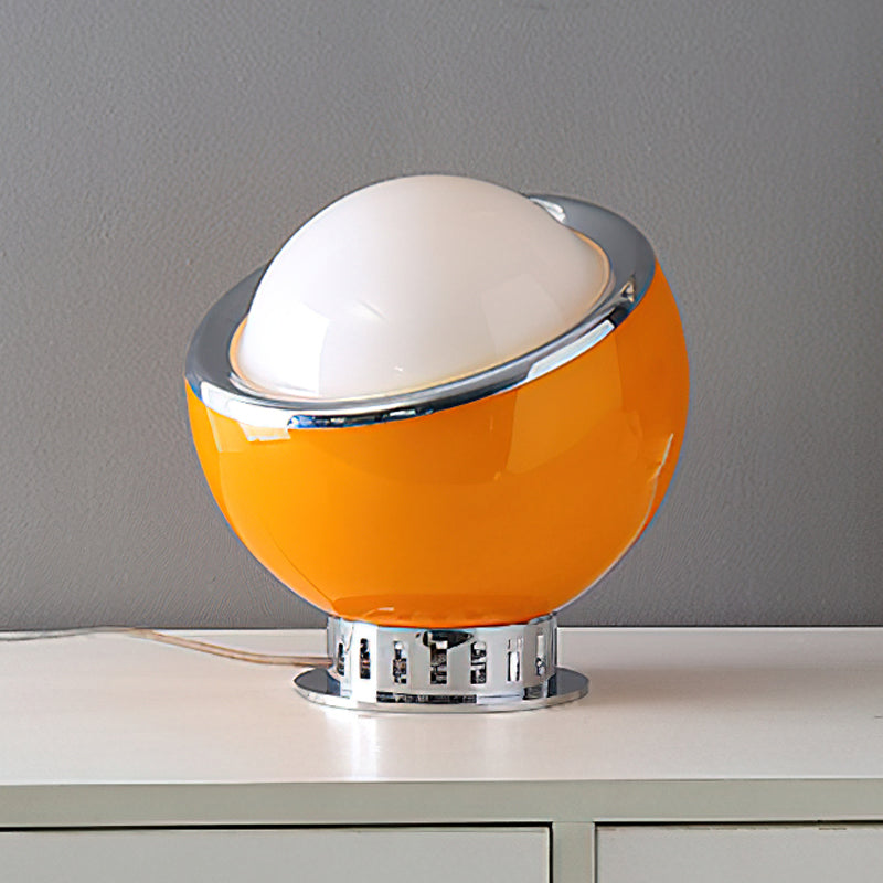 Orange Clérachic table lamp with a white dome and chrome ring on a ribbed chrome base, standing on a white cabinet.