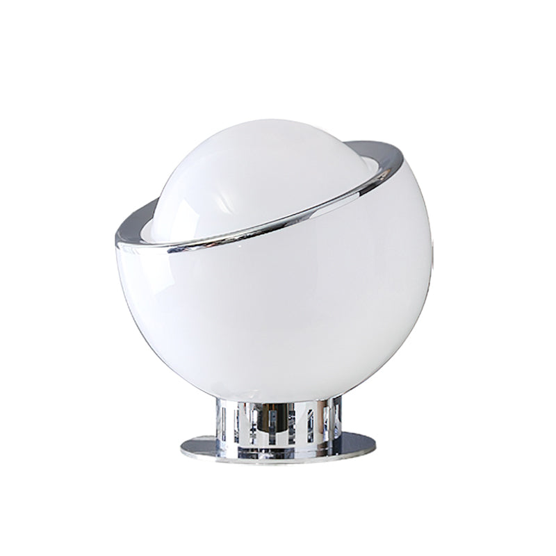 White glass Clérachic table lamp with a tilted chrome ring and a ribbed chrome base on a flat chrome plate, on a white backdrop.