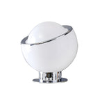 White glass Clérachic table lamp with a tilted chrome ring and a ribbed chrome base on a flat chrome plate, on a white backdrop.