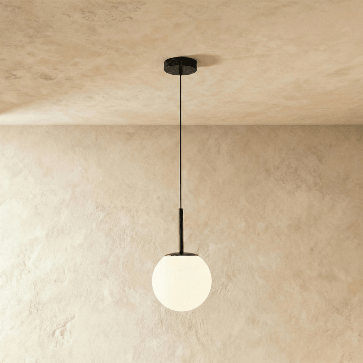 Clérachic Cells pendant light in Straight, Black, a matte black rod holding a frosted glass globe from a plaster ceiling.
