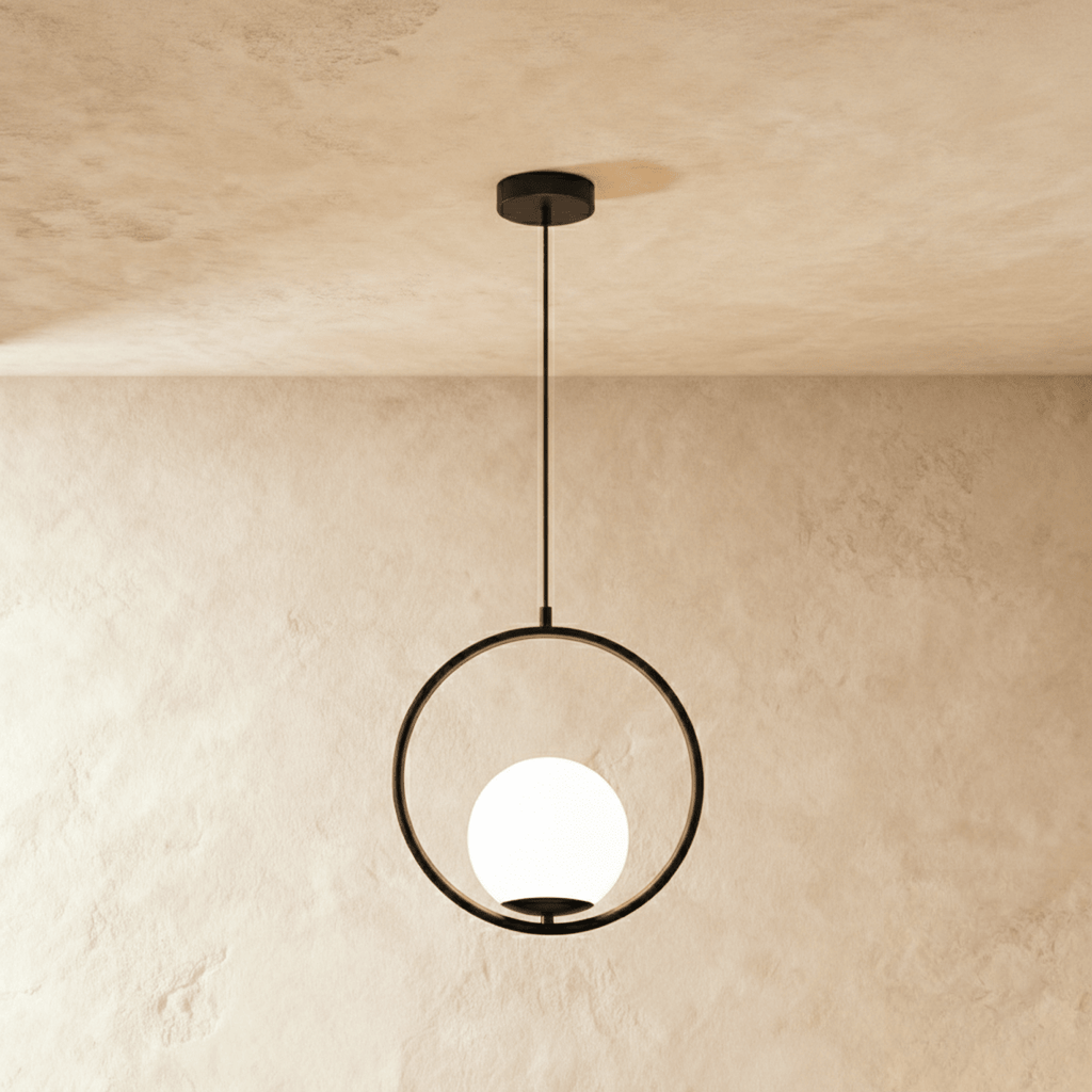 Clérachic Cells pendant light in Circle, Black, a matte black ring cradling a frosted glass globe against plaster.