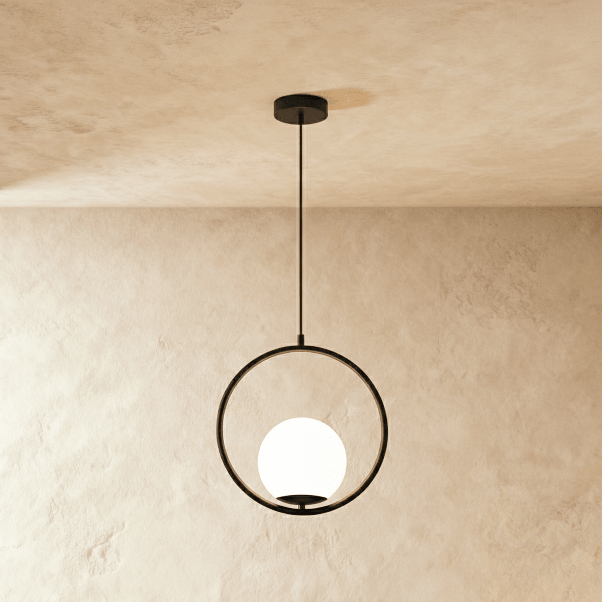 Clérachic Cells pendant light in Circle, Black, a matte black ring cradling a frosted glass globe against plaster.