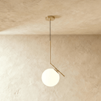 Clérachic Cells pendant light in the Canted profile, Brass, an angled brass rod holding a frosted glass globe.