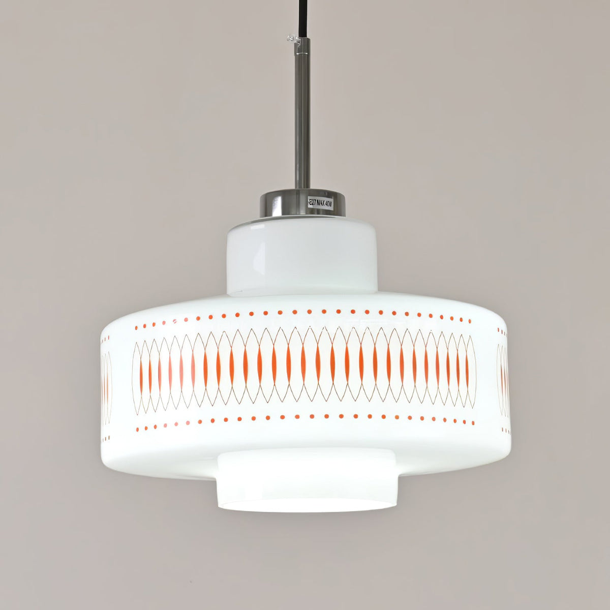 Close view of the stepped opal glass shade and orange printed band on this Clérachic pendant, with a chrome cap above.