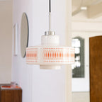 Clérachic pendant with a white glass shade and orange print hangs in a hallway, with a round mirror and an arched window.