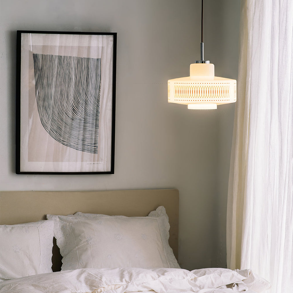 A Clérachic pendant glows beside a window curtain, above a bed headboard and a framed line-art print.