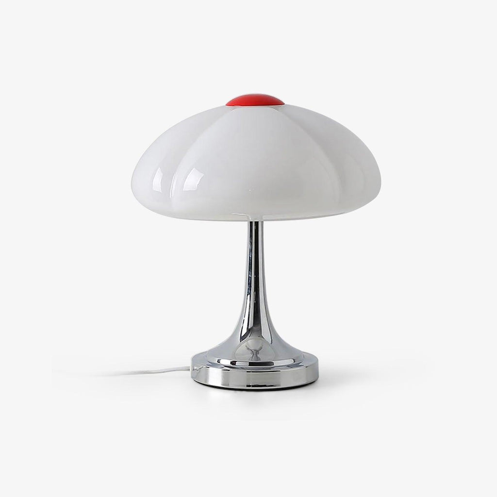 This Clérachic table lamp on a plain white backdrop, a white lobed glass shade with a red cap on a slim chrome stem and round base.