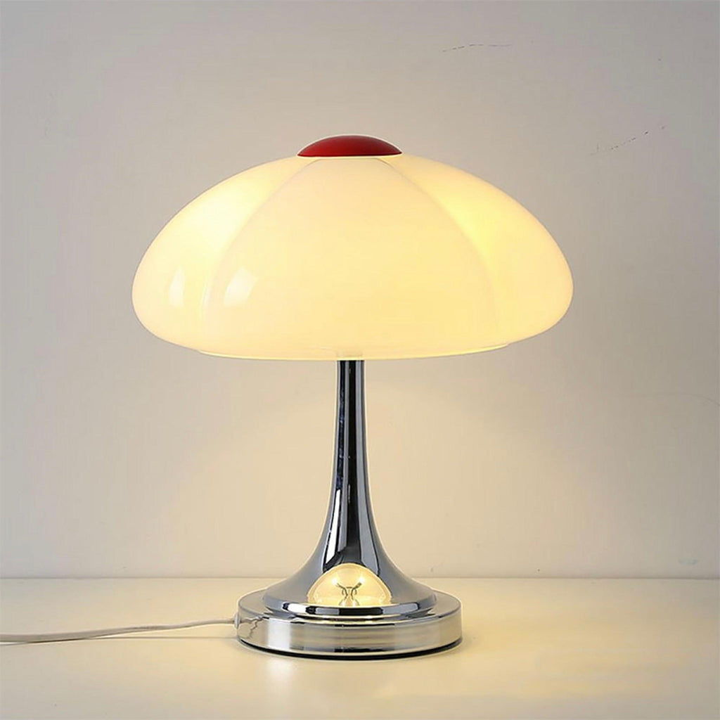 Tight view of this Clérachic lamp lit on a white ledge, the whole shade glowing evenly above the chrome stem.