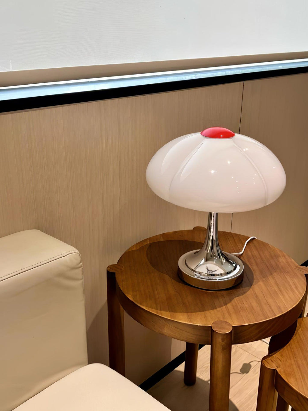 This Clérachic table lamp on a round walnut side table in a cream-toned corner, seen from a few steps back.