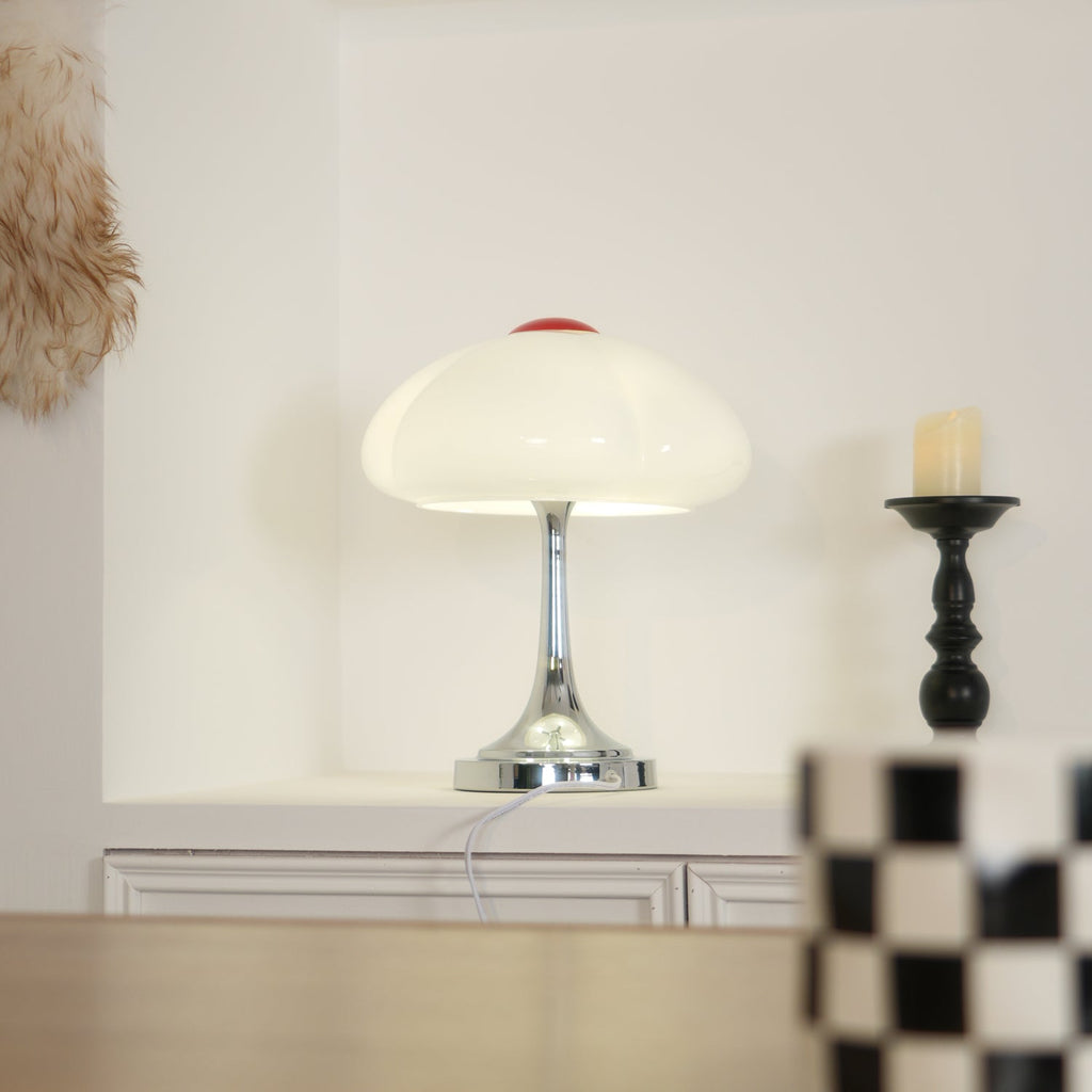 Pale glow from this Clérachic lamp beside a black candlestick on a white ledge, with a checked mug in the foreground.