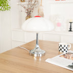 This Clérachic table lamp unlit on a wooden desk, a checked mug and magazine beside it and a plant in the background.