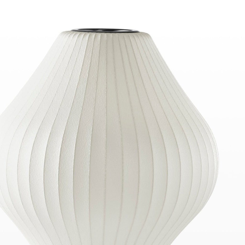 Close view of the white ribbed, pear-shaped shade of this Clérachic table lamp, its fabric-like texture visible.