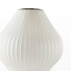 Close view of the white ribbed, pear-shaped shade of this Clérachic table lamp, its fabric-like texture visible.