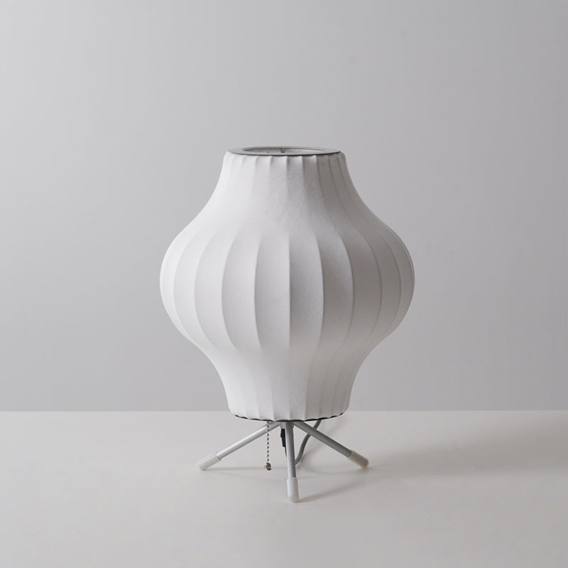Unlit pear-shaped white Clérachic table lamp on a pale grey set, with a pull chain hanging between its tripod legs.