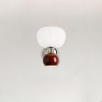 A deep red ball under a ribbed white glass shade on this Clérachic chrome wall light, shown on a plain pale wall.