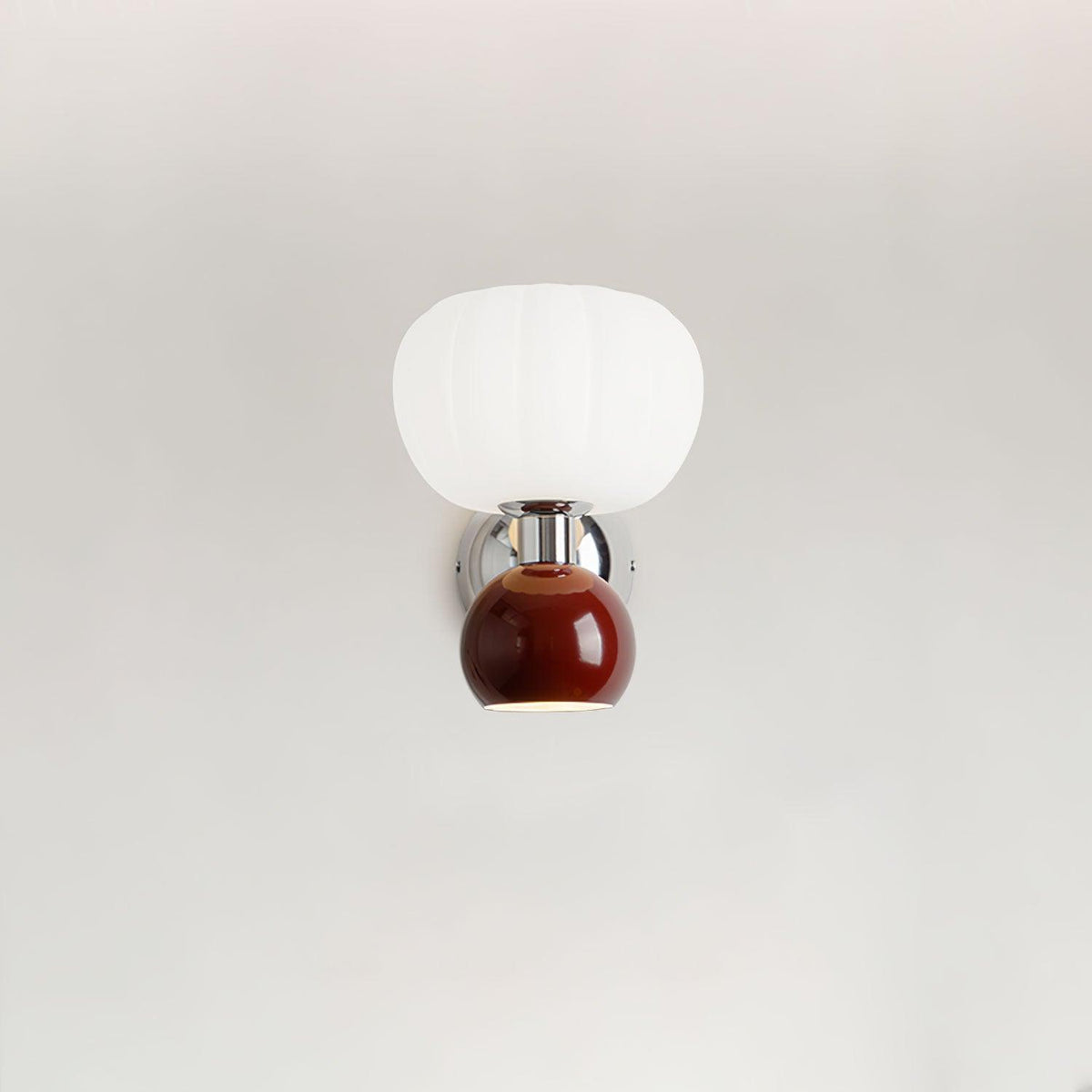 A deep red ball under a ribbed white glass shade on this Clérachic chrome wall light, shown on a plain pale wall.